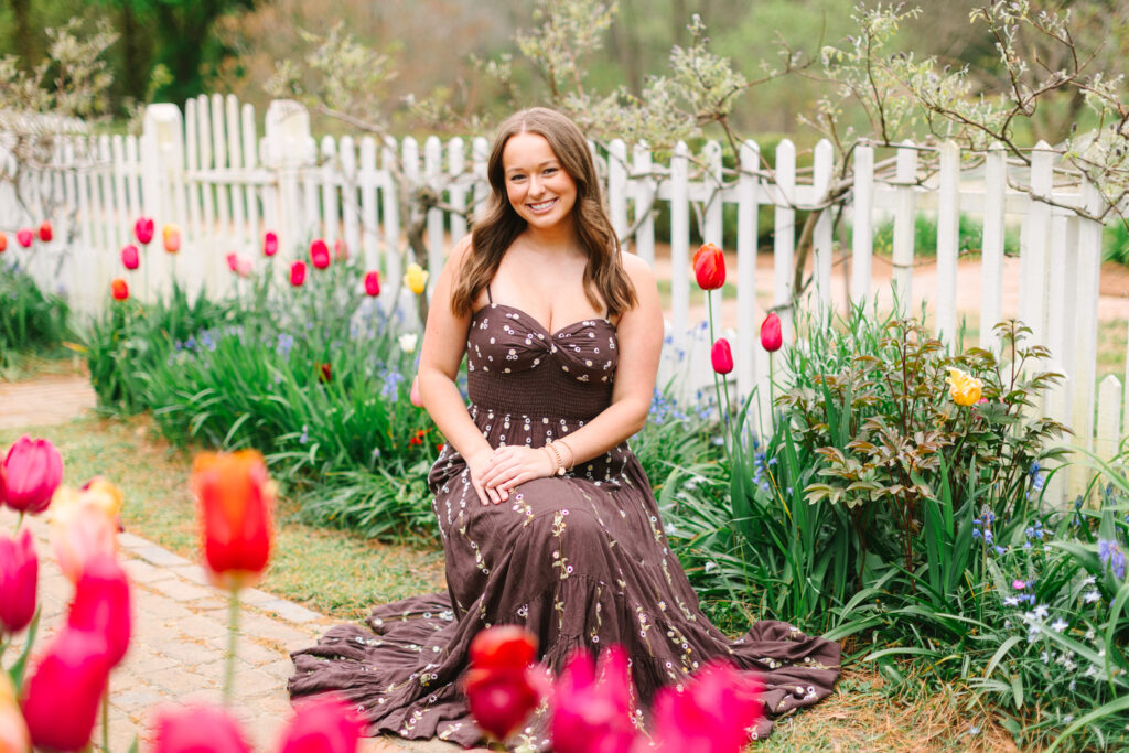 High school senior posing among vibrant tulips during a spring mini session in Colonial Williamsburg.