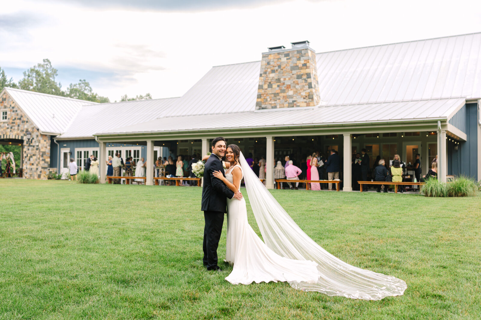 Bride and groom portraits in front of the back of the Maine porch during cocktail hour