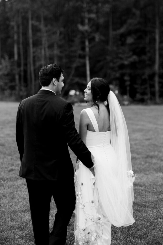Emotional black and white portrait of the bride and groom walking at The Maine of Williamsburg