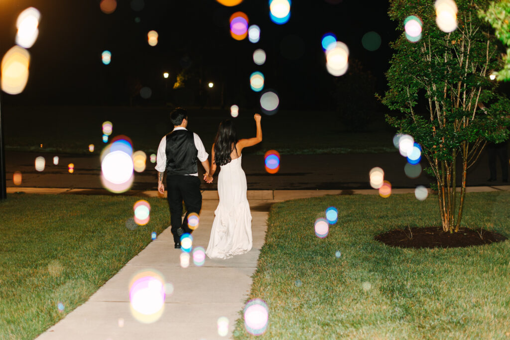 Bride and groom surrounded by bubbles during their wedding exit at The Maine of Williamsburg
