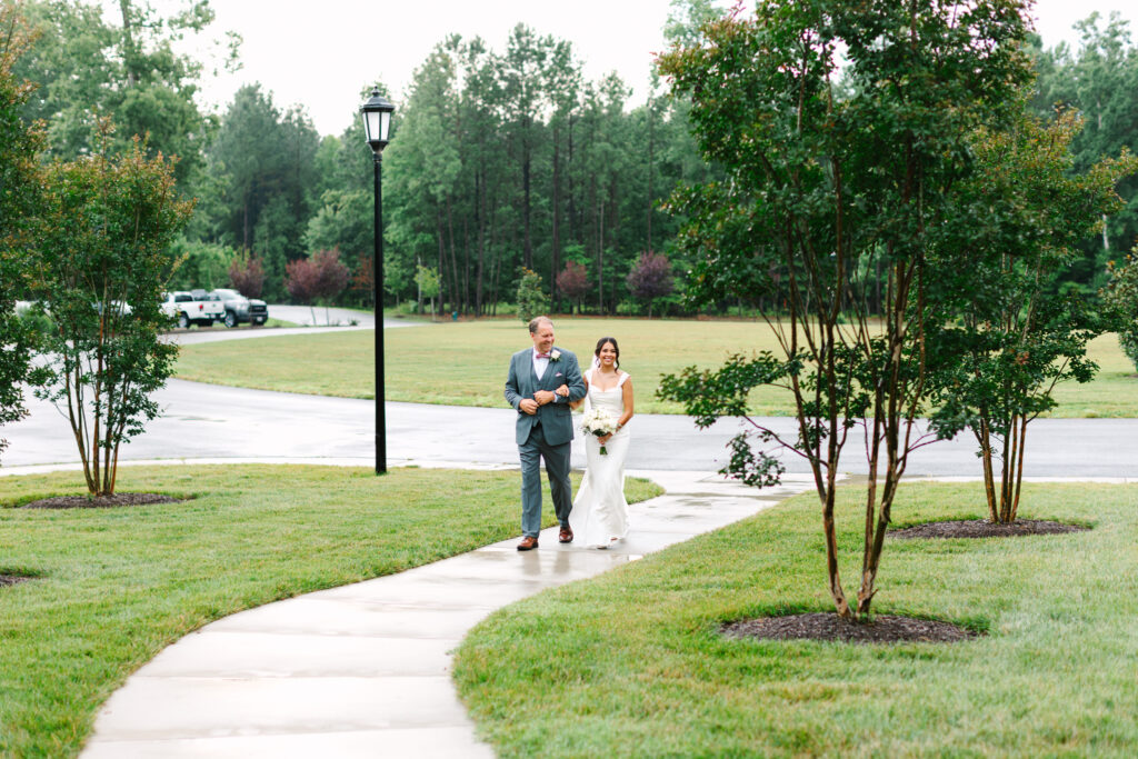 Bride and her father walking down the aisle during the ceremony at The Maine of Williamsburg