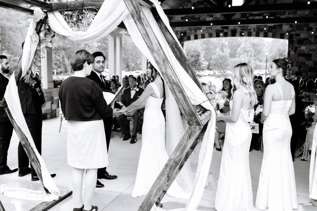 Bride and groom during the ceremony photographed through the arch at The Maine of Williamsburg
