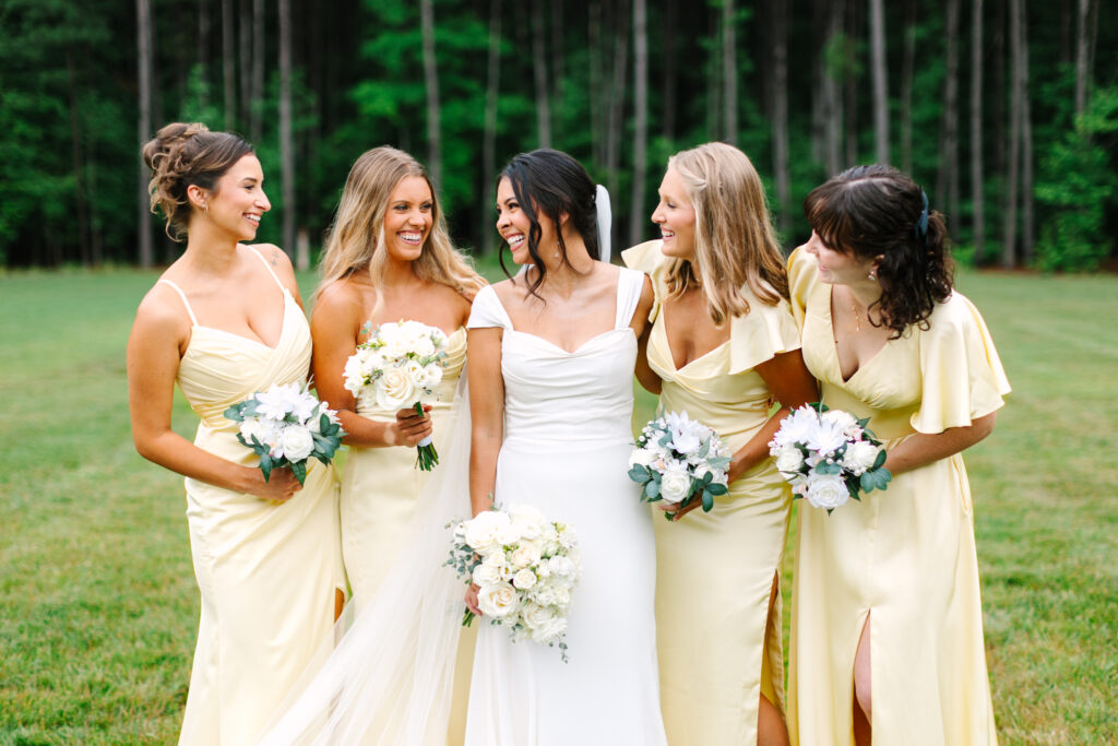 Bride laughing with her bridesmaids at The Maine of Williamsburg