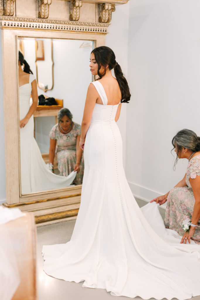 Bride’s mother helping her into her wedding dress at The Maine of Williamsburg