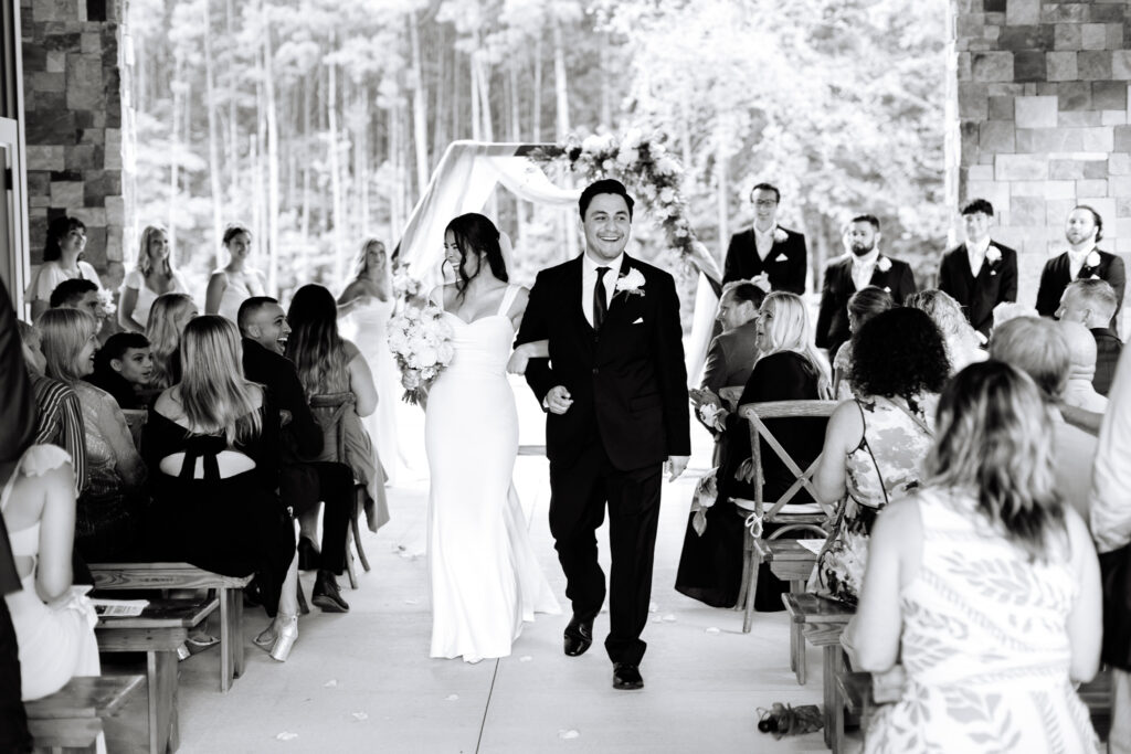 Bride and groom walking back down the aisle during the recessional at The Maine of Williamsburg
