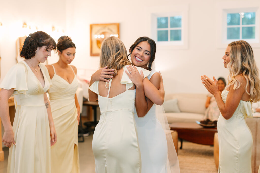Bride sharing a first look with her bridesmaids and flower girl during a wedding at The Maine of Williamsburg