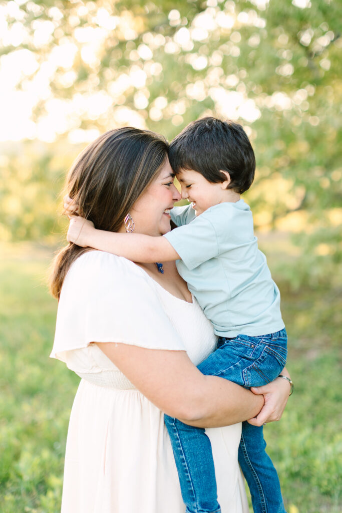 Mother holding her young son as they smile and touch noses during a summer mini session in Yorktown, Virginia.