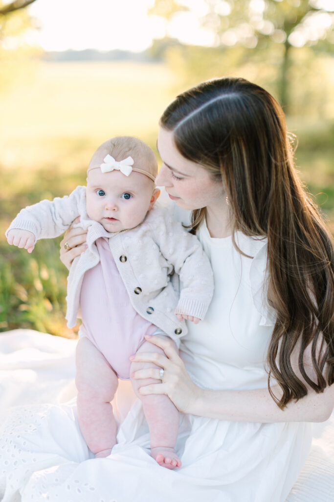 A sweet moment capturing a photo of mother and new baby daughter during family photos in Yorktown, Virginia during a Yorktown Summer Mini Session.